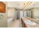 Bright bathroom featuring dual sinks, a soaking tub, and shower at 9896 Sw 56Th Ct, Ocala, FL 34476