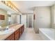 Bright bathroom featuring dual sinks, a soaking tub, and shower at 9896 Sw 56Th Ct, Ocala, FL 34476