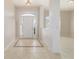 Inviting home foyer featuring light tile flooring with a decorative accent design and an elegant glass-paneled front door at 9896 Sw 56Th Ct, Ocala, FL 34476
