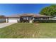 Lovely single-story home with a manicured lawn, mature shrubs, and an attached two-car garage at 9896 Sw 56Th Ct, Ocala, FL 34476