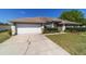Nice single-story home featuring a well-kept lawn, mature landscaping, and a convenient two-car garage at 9896 Sw 56Th Ct, Ocala, FL 34476