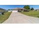 Inviting single-story home featuring a well-maintained lawn, mature shrubbery, and a convenient two-car garage at 9896 Sw 56Th Ct, Ocala, FL 34476