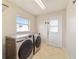 Well-lit laundry room equipped with modern washer and dryer units and direct access to the outdoors at 9896 Sw 56Th Ct, Ocala, FL 34476