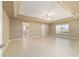 Spacious living room with tray ceilings, neutral paint, and tile flooring offering a versatile living space at 9896 Sw 56Th Ct, Ocala, FL 34476