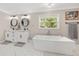 Modern bathroom boasts double vanities, a soaking tub, and marble floors at 9950 Nw 11Th Ter, Ocala, FL 34475