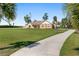 Inviting one-story home featuring a spacious front lawn and long driveway surrounded by mature landscaping and trees at 9950 Nw 11Th Ter, Ocala, FL 34475