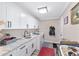 Bright laundry room featuring modern cabinets, a sink, and an efficient washer and dryer at 9950 Nw 11Th Ter, Ocala, FL 34475