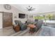 Relax in this inviting living room featuring cozy seating, a large TV, and seamless access to the outdoor pool area at 9950 Nw 11Th Ter, Ocala, FL 34475