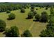 Beautiful aerial view of expansive acreage featuring mature trees, green grass and an overgrown road at 11420 Nw 110Th Ave, Reddick, FL 32686