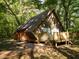 Unique A-frame home showcasing a rustic exterior with wooden accents, nestled in a serene wooded setting at 11420 Nw 110Th Ave, Reddick, FL 32686