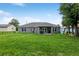 Charming backyard with a covered patio, outdoor dining set, and lush green lawn at 12 Oak Circle Pass, Ocala, FL 34472