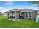 Charming backyard features a covered patio, outdoor dining, grill, and ample green space at 12 Oak Circle Pass, Ocala, FL 34472