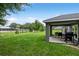 This spacious backyard features a covered patio with outdoor seating and a grill at 12 Oak Circle Pass, Ocala, FL 34472