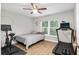 Bright bedroom features a ceiling fan, large window, and exercise equipment for a convenient workout space at 12 Oak Circle Pass, Ocala, FL 34472