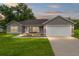 Charming single-story home with a well-manicured lawn and a two-car garage under a picturesque sunset at 12 Oak Circle Pass, Ocala, FL 34472