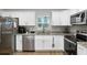Bright kitchen features granite countertops, stainless steel appliances, and white cabinetry at 12 Oak Circle Pass, Ocala, FL 34472