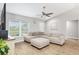 Bright living room featuring a comfortable sectional sofa, ceiling fan, and large window for natural light at 12 Oak Circle Pass, Ocala, FL 34472