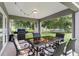 View of the covered patio featuring an outdoor dining set, grill, and backyard views at 12 Oak Circle Pass, Ocala, FL 34472