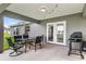 This covered patio features a dining table and grill, ideal for enjoying outdoor meals and backyard barbecues at 12 Oak Circle Pass, Ocala, FL 34472