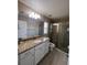 Bathroom featuring granite counters, white cabinets, and a glass-enclosed shower at 12840 Sw 60Th Ct, Ocala, FL 34473