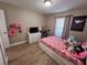 Cozy bedroom featuring a bright window, stylish decor, and wood-look flooring at 12840 Sw 60Th Ct, Ocala, FL 34473