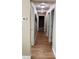 Hallway with wood floors, neutral walls, and access to a bathroom and other rooms at 12840 Sw 60Th Ct, Ocala, FL 34473
