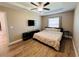 Main bedroom with tray ceiling, wood laminate flooring, and dark colored furniture at 12840 Sw 60Th Ct, Ocala, FL 34473