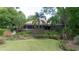 Landscaped backyard featuring mature trees and a patio area, creating a serene and private outdoor space at 1450 Se 73Rd Pl, Ocala, FL 34480