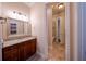 Bathroom vanity with granite counters and dark wood cabinets, mirror, with attached toilet room at 1450 Se 73Rd Pl, Ocala, FL 34480