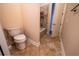Standard toilet beside a bathtub with tile surround and flooring in a neutral color scheme, with an open door at 1450 Se 73Rd Pl, Ocala, FL 34480