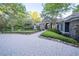Long driveway with stone pillars leading to a well-maintained home surrounded by lush trees at 1450 Se 73Rd Pl, Ocala, FL 34480