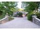 Long driveway with stone pillars leading to a well-maintained home surrounded by lush trees at 1450 Se 73Rd Pl, Ocala, FL 34480