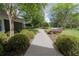 Charming walkway leading to the home, surrounded by lush landscaping and mature trees at 1450 Se 73Rd Pl, Ocala, FL 34480