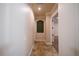 Hallway with neutral walls, tile floors, arched window and doorway leading to a room at 1450 Se 73Rd Pl, Ocala, FL 34480