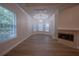 Sunlit living room with a fireplace, tray ceiling, and large windows offering scenic views at 1450 Se 73Rd Pl, Ocala, FL 34480