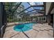 Screened pool area with a spa, patio, and lush green views, perfect for outdoor enjoyment at 1450 Se 73Rd Pl, Ocala, FL 34480