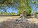 Backyard play structure with slide and lattice, set in a spacious, fenced yard with mature trees at 14978 Sw 46Th Cir, Ocala, FL 34473