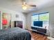 Cozy bedroom with a ceiling fan, modern entertainment center, and a bright window at 14978 Sw 46Th Cir, Ocala, FL 34473