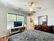 Comfortable bedroom with a ceiling fan, large window providing natural light, and dark wood furniture at 14978 Sw 46Th Cir, Ocala, FL 34473