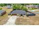 Exterior view of a cozy home with a two-car garage, a concrete driveway, and lush landscaping at 14978 Sw 46Th Cir, Ocala, FL 34473