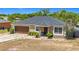 Charming home featuring a well-maintained lawn, mature landscaping, and a welcoming front entrance with a two car garage at 14978 Sw 46Th Cir, Ocala, FL 34473