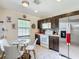 Bright kitchen featuring a dining area, stainless steel refrigerator and tiled flooring at 14978 Sw 46Th Cir, Ocala, FL 34473