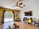 Bright living room with wood floors, ceiling fan, entertainment center, and sliding glass doors to the backyard at 14978 Sw 46Th Cir, Ocala, FL 34473