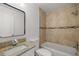 Bathroom featuring shower over tub, tile walls, granite vanity and sink, and a decorative mirror at 15044 Sw 35Th Avenue Rd, Ocala, FL 34473