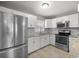 Updated kitchen features stainless steel appliances and granite countertops with white cabinets at 15044 Sw 35Th Avenue Rd, Ocala, FL 34473