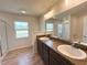 Bright bathroom featuring a double sink vanity with granite countertops and wood-look flooring at 15317 Sw 65Th Terrace Rd, Ocala, FL 34473