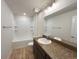 Well-lit bathroom has a large vanity with granite countertop, and a shower-tub combo with shelving at 15317 Sw 65Th Terrace Rd, Ocala, FL 34473