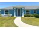 Close-up of a home's entrance, featuring a gray front door, sidelight windows, and a concrete walkway at 15317 Sw 65Th Terrace Rd, Ocala, FL 34473
