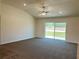 Spacious living room features vaulted ceiling, modern ceiling fan and large sliding glass doors to the back at 15317 Sw 65Th Terrace Rd, Ocala, FL 34473