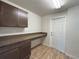 Functional mudroom with wood cabinets, countertop space, and access to an exterior door at 15317 Sw 65Th Terrace Rd, Ocala, FL 34473